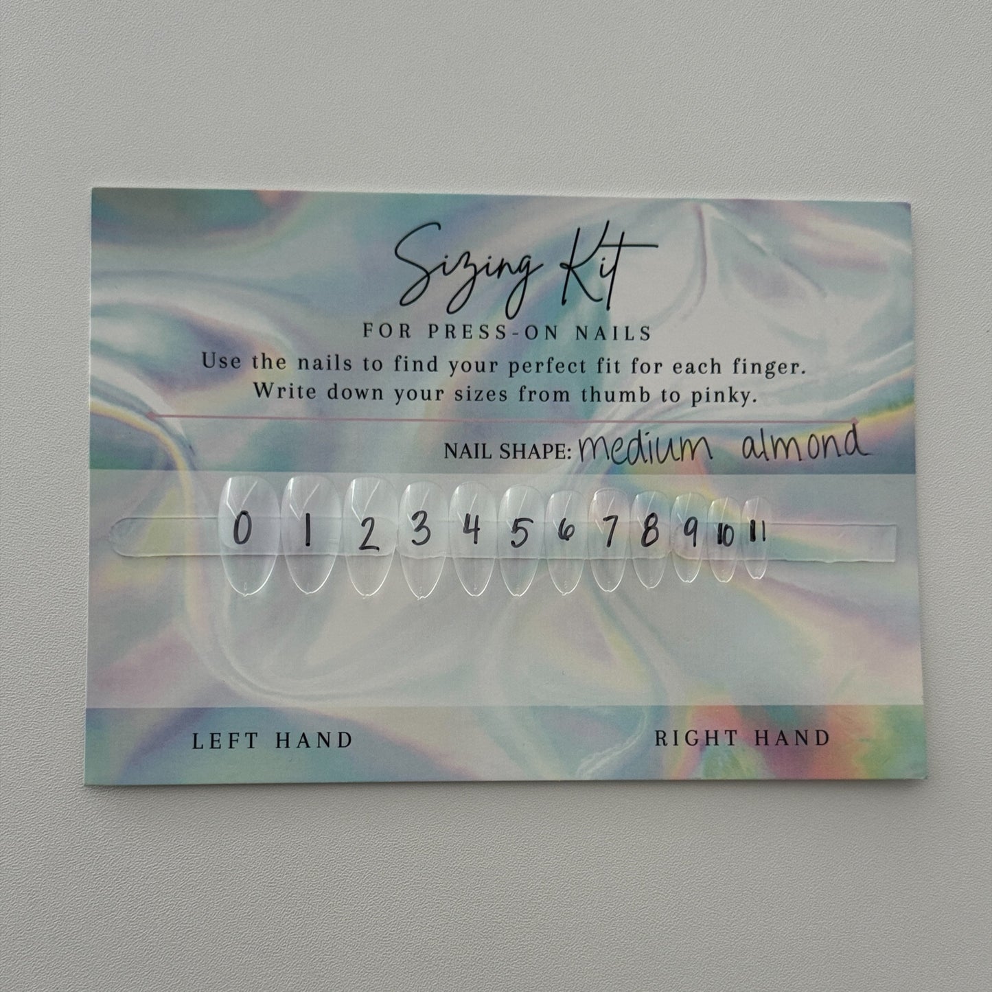 Nail extension sizing kit with numbers on a gray background