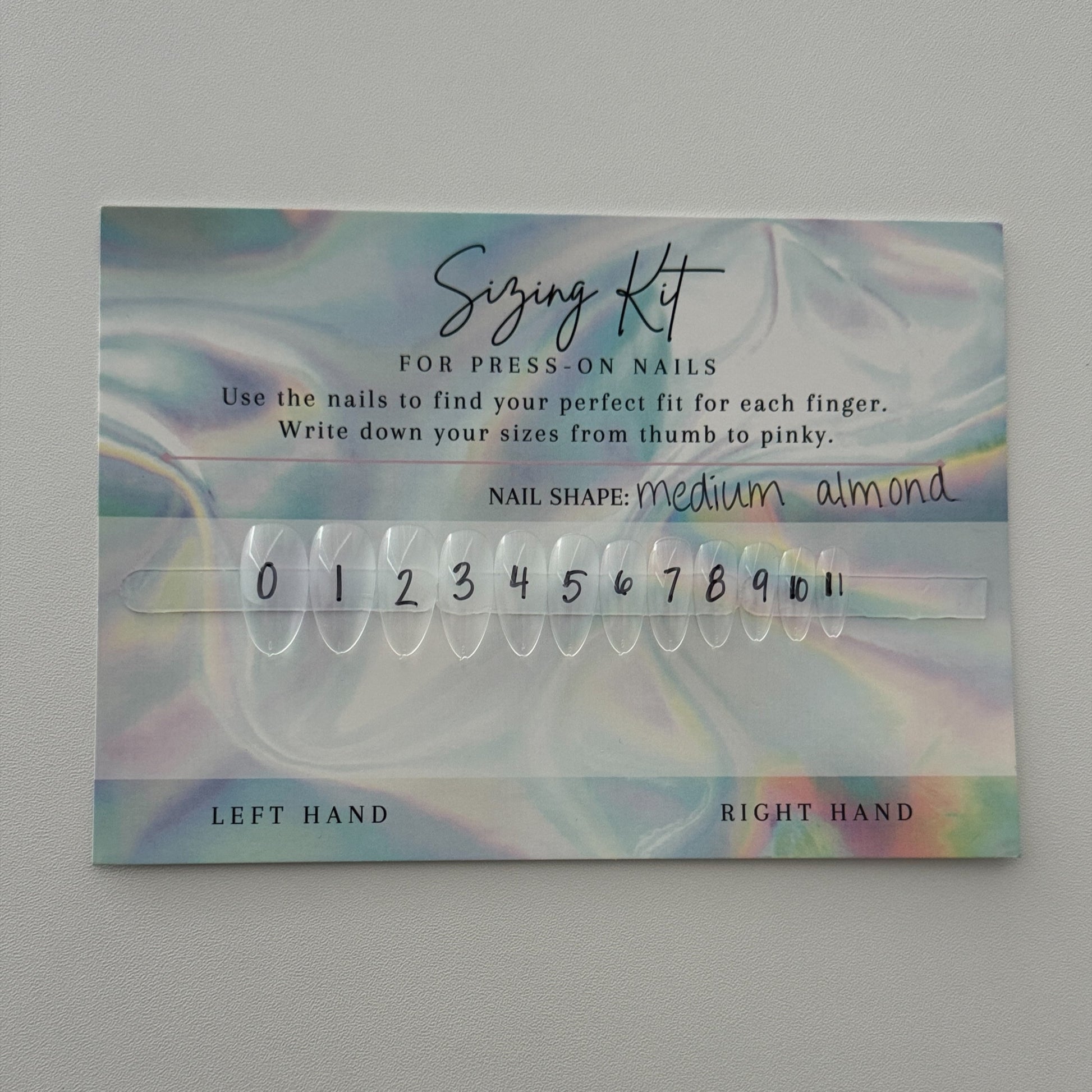 Nail extension sizing kit with numbers on a gray background